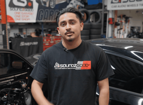 SoundzGood Garage employee explaining a car stereo upgrade inside the shop
