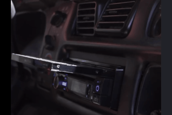 Close-up of a newly upgraded retractable touchscreen head unit installed in a car dashboard.