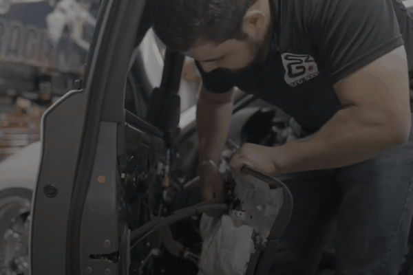 SoundzGood Garage technician installing a new car stereo system inside a vehicle