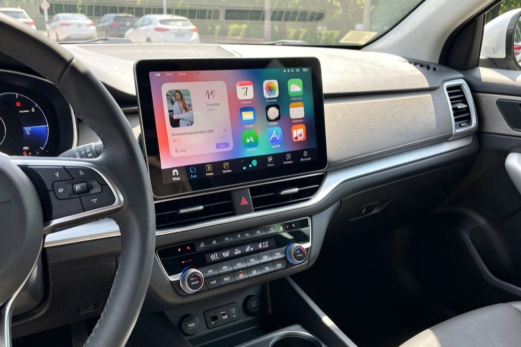 Modern car interior with Apple CarPlay displayed on a central touchscreen above climate controls and steering wheel buttons in view.
