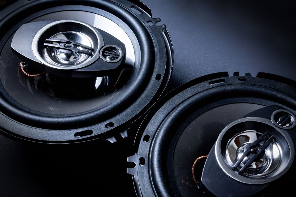 Pair of high-performance coaxial car speakers on dark background
