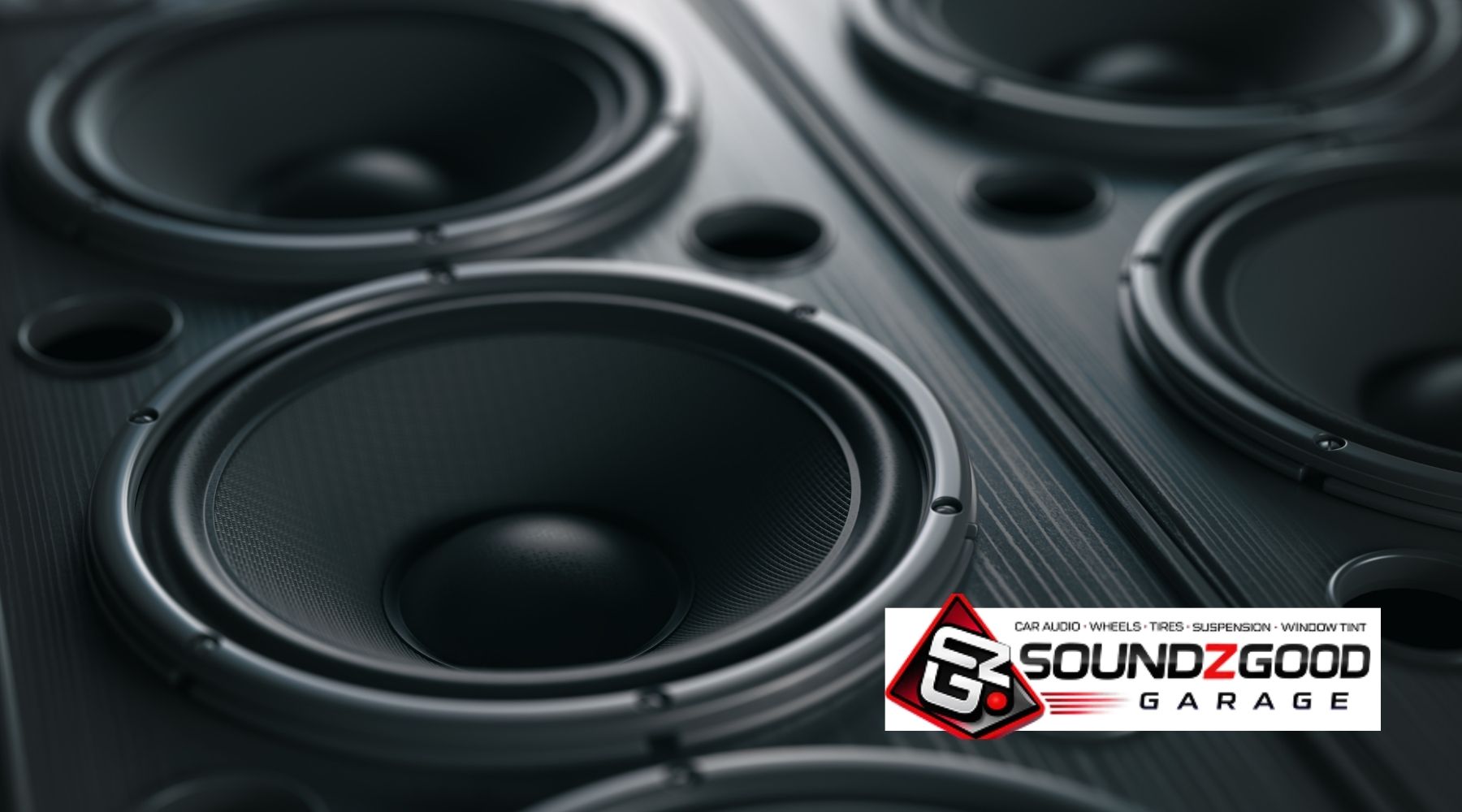 Multiple car subwoofers mounted in a custom enclosure for professional car audio installation
