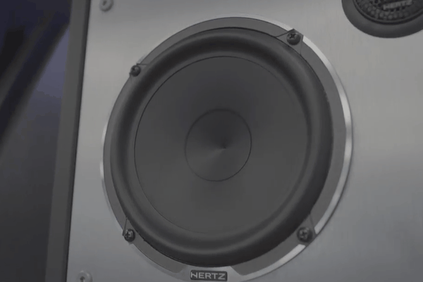 Close-up of a high-performance Hertz car speaker mounted on a panel