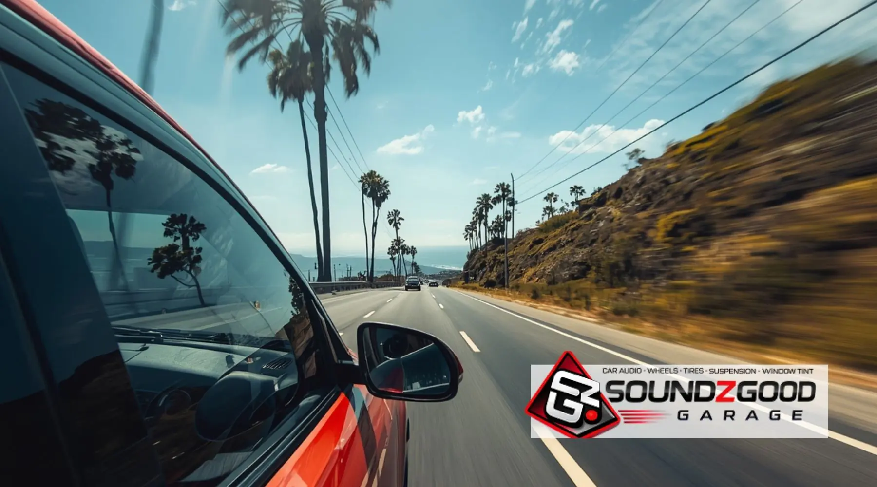 Car with tinted windows driving along a sunny Southern California coastal highway with Soundz Good Garage logo overlay.