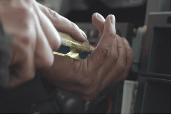 Close-up of a technician using a hand tool during a car audio dashboard installation