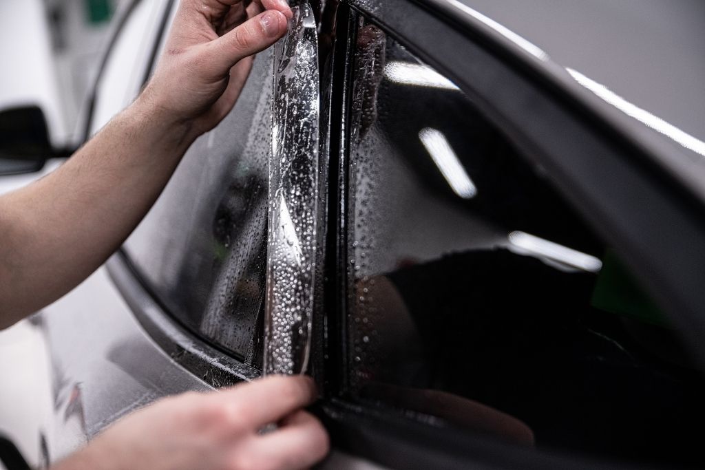 Close-up of automotive window film being applied to a car window