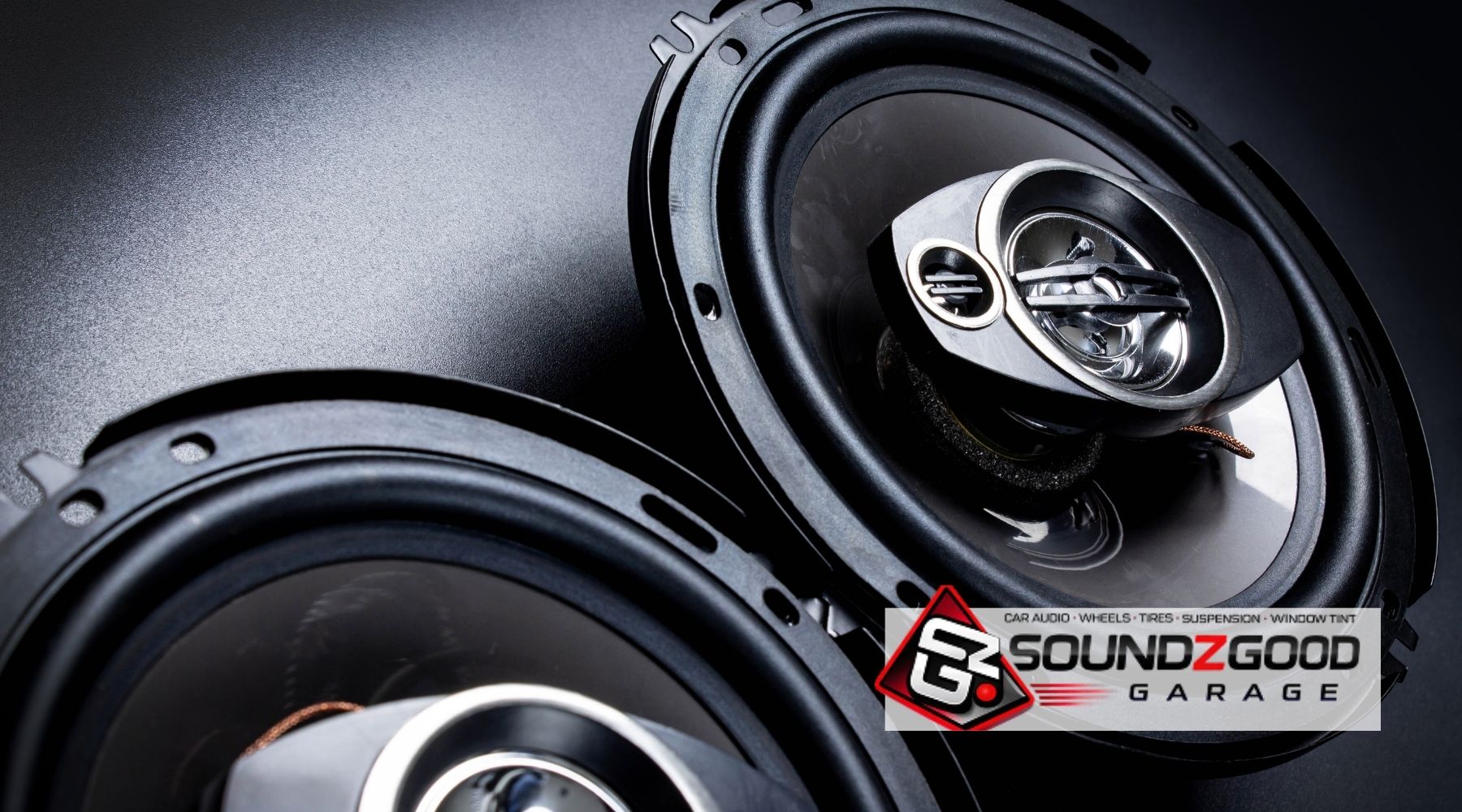 Two aftermarket car speakers with the Soundz Good Garage logo, representing professional car speaker upgrades in Oxnard, CA.