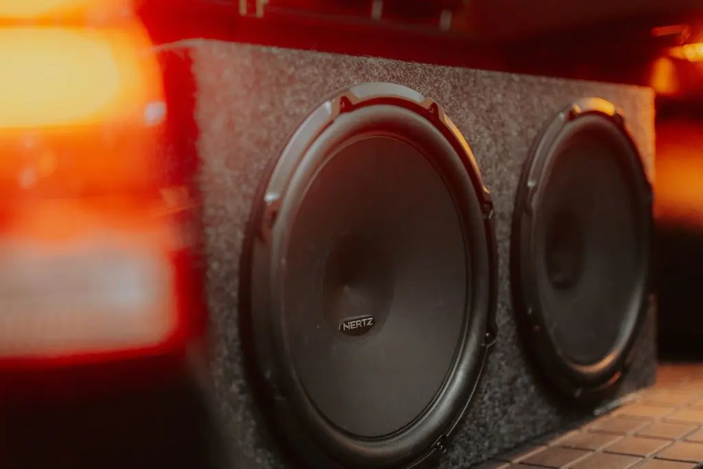 Dual car subwoofers installed in an enclosure, designed to deliver deeper bass and stronger low-frequency sound.