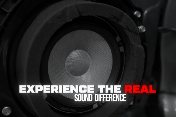 Close-up of an Alpine car speaker with the text “Experience the Real Sound Difference.”